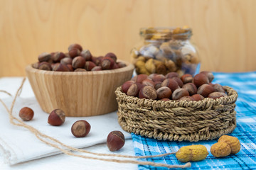 Hazelnuts in a wooden bowl and wicker basket. Composition of nuts.