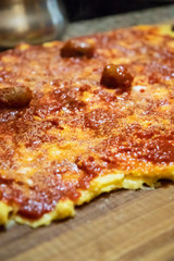 Cooking polenta, typical, traditional, Italian food made with cornmeal and water. Polenta topped with sausage and pork with gravy, on wooden pastry. Lunch at home with the family.