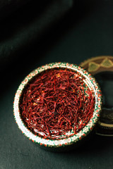 Dried saffron spice on dark background.