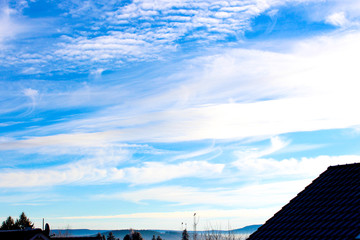 Fototapeta premium blue sky background with clouds in front of houses