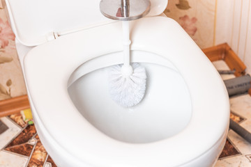 Cleaning of toilet with scrap brush. 