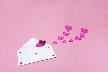 Symbolic image of Valentine's day postal envelope, hearts, pink background .
