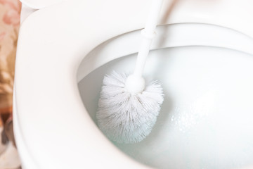 Cleaning of toilet with scrap brush. 