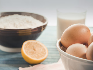 natural ingredients to prepare a cake: eggs, milk, lemon, flour