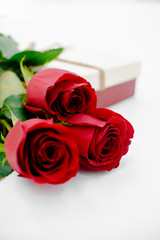 Fototapeta premium Flowers composition with gift box heart shaped made of rose flowers on white background. Flat lay, top view, copy space