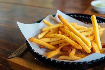 French fries in bowl on dark wooden background