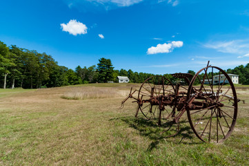 Fototapeta na wymiar old plough on a farm landscape in Maine, USA