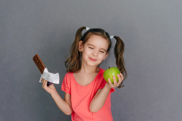 Sweet tooth baby chocolate or green Apple. Healthy and harmful food in baby food. Selective focus.