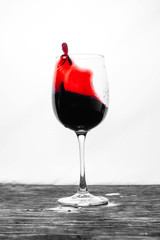 Red wine in the glass splashes in action on a white background. Stylish design card