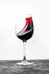 Red wine in the glass splashes in action on a white background. Stylish design card