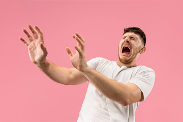 I'm afraid. Fright. Portrait of the scared man. Business man standing isolated on trendy pink...