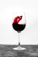 Red wine in the glass splashes in motion on a white background. Design card