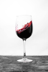 Red wine in the glass splashes in action on a white background. Design card