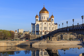 Fototapeta na wymiar Cathedral of Christ the Saviour and Patriarshiy Bridge over Moskva river on a blue sky background in sunny spring morning