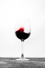 Red wine in the glass splashes in motion on a white background. Stylish design drink card