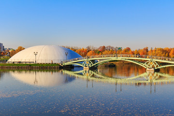 Bridge over pond against blue sky in Tsaritsyno park in Moscow at sunny autumn day