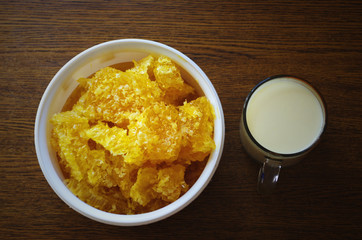 Milk and bee's cells, honey on the wooden table