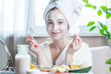 Obraz na płótnie Canvas Beautiful happy young woman with natural cosmetic mask on her face. Concept skin care and Spa treatments