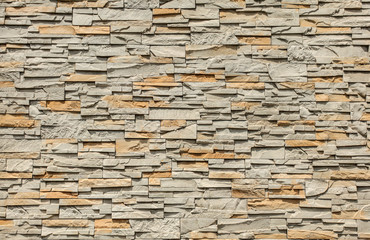 Tiled stone wall made of rectangular blocks, sun shining from top.