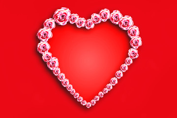 Beautiful heart made up of pink roses on a red background.