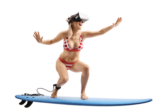 Young woman in bikini surfing with a VR set