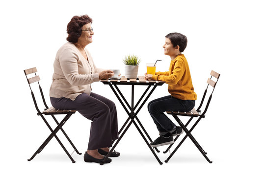 Grandmother sitting at a coffee table and talking to her grandson