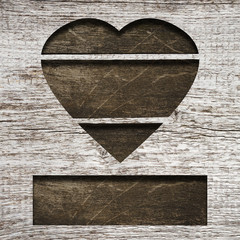 Dark wooden heart on a gray wooden background. Concept for Valentine's Day.