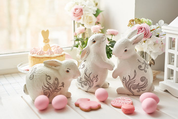 Easter cake with gingerbread on the table, the table is decorated with flowers, rabbits and eggs