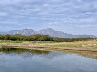 Shoreline of Lake El Salto a famous freshwater bass fishing spot in Sinaloa, Mexico, with the Sierra Madre Mountains in the background