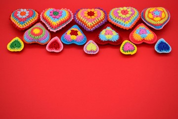Valentine's day. Background of hearts on a red background. Amigurumi, handmade, knitted.