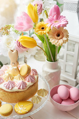Easter composition with sweet bread, Easter cake, eggs, bouquet of flowers. Holidays breakfast concept with copy space. Traditional easter cake with gingerbread cookies. Easter Greeting Card Template