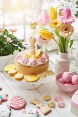 Fototapeta na wymiar Easter composition with sweet bread, Easter cake, eggs, bouquet of flowers. Holidays breakfast concept with copy space. Traditional easter cake with gingerbread cookies. Easter Greeting Card Template