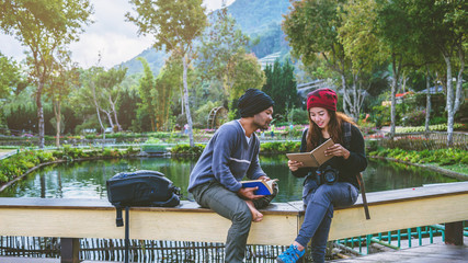 Asian couple travel photograph nature education. nature relax and study read a book. at public park. In Thailand