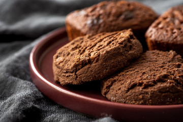 Chocolate cookies on a plate, dark background.