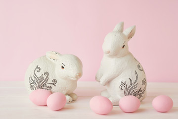 Easter bunny rabbit with pink painted egg on pink background. Easter holiday concept. Greeting card template Easter Bunny. Happy Easter holiday background concept.