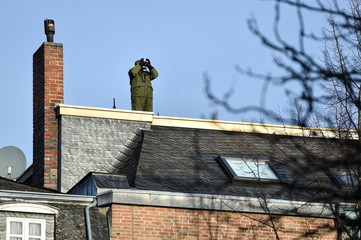 sniper securing a perimeter from a rooftop