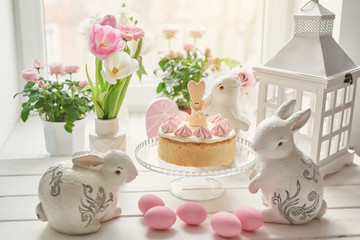 Easter composition with  sweet bread, kulich and eggs with rabbits. Easter holidays breakfast concept with copy space. Easter Greeting Card Template. Easter eggs with cake on white wooden table