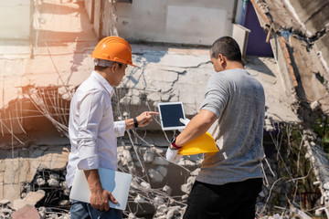 Demolition control supervisor and foreman discussing on demolish building.