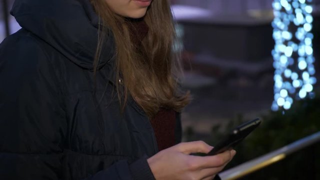Young woman is sending a text message on her cell phone