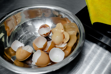 kitchen utensils and cups with broken egg and eggs shells. Cooking and kitchen concept, horizontal top view, several objects. Steel bole