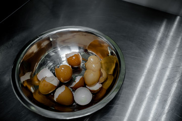 kitchen utensils and cups with broken egg and eggs shells. Cooking and kitchen concept, horizontal top view, several objects. Steel bole