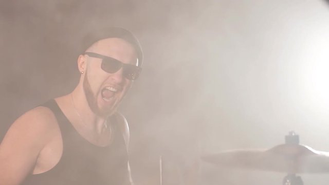Talented emotional man plays the drums in studio. Hobby, lifestyle