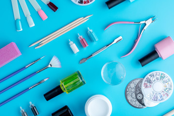 Set of cosmetic tools for professional manicure and nail care on blue background. Top view