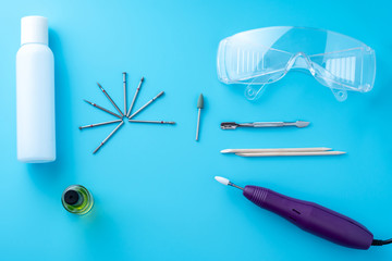 Set of cosmetic tools for professional hardware manicure on a blue background. Milling cutter, top view