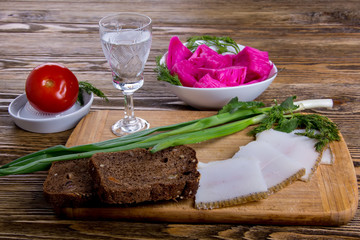 Russian tradition. A glass of vodka and a snack. Lard, black bread, pickled cabbage, pickled tomato, greens 2