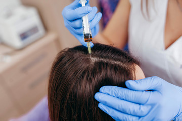 Naklejka premium Young woman with hair loss problem receiving injection, close up