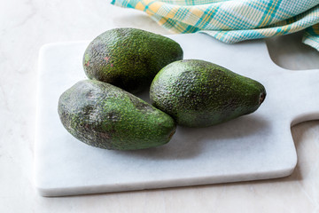 Organic Whole Ripe Avocado on Marble Board.