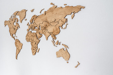 Wooden world map on a white wall. Geography concept. Background for travel. Logistics and transportation, worldwide business. All continent. Europe, America, Australia and Asia.