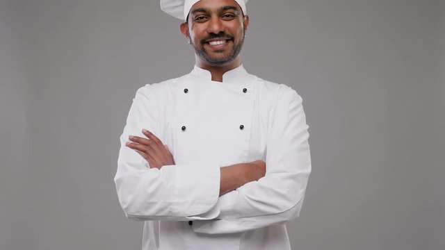 cooking, profession and people concept - happy male indian chef in toque over grey background