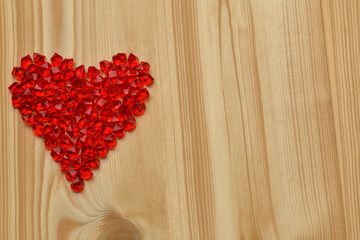 Valentine's day. A large red plastic glass heart made of small crystals lies on a light tree. Horizontal photography.